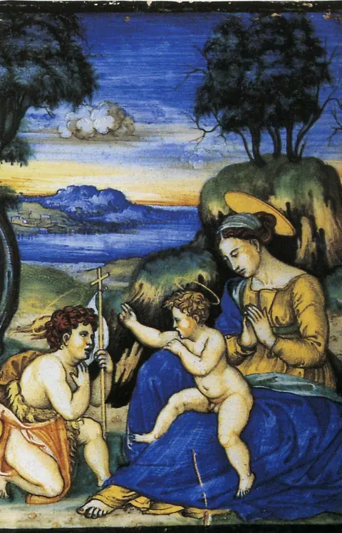 La Madonna col Bambino e san Giovannino dipinta su una placca di maiolica, coi blu e i gialli del Cinquecento