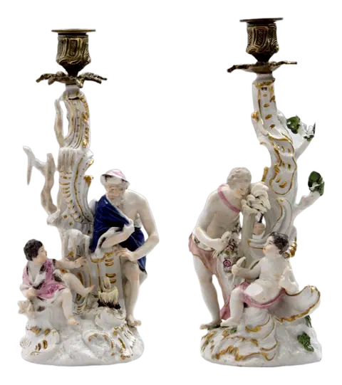 Due candelieri di porcellana bianca con figure dipinte e i bracci dorati